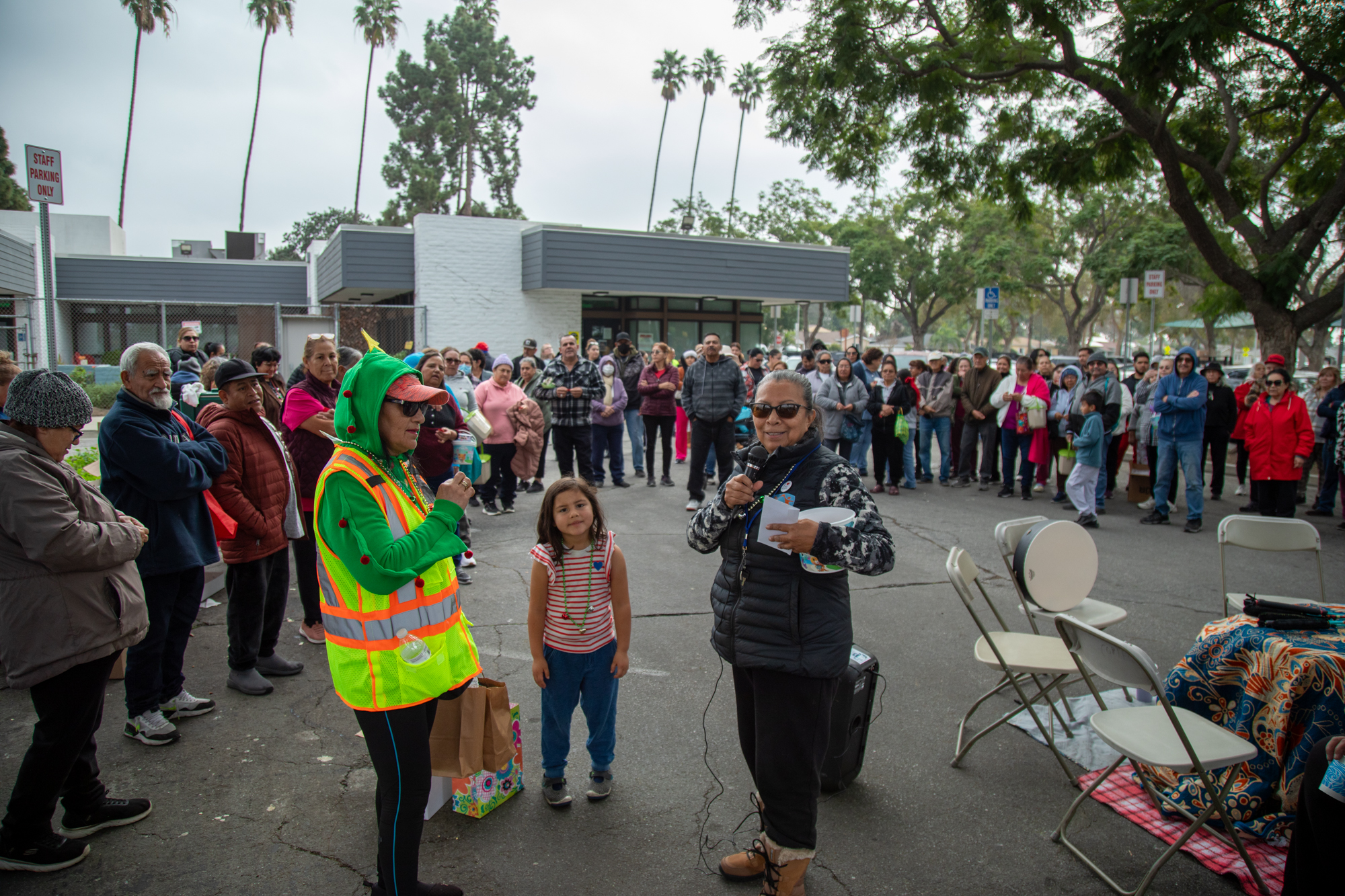 Neighbors gathered as a Puente organizer speaks at a community food distribution